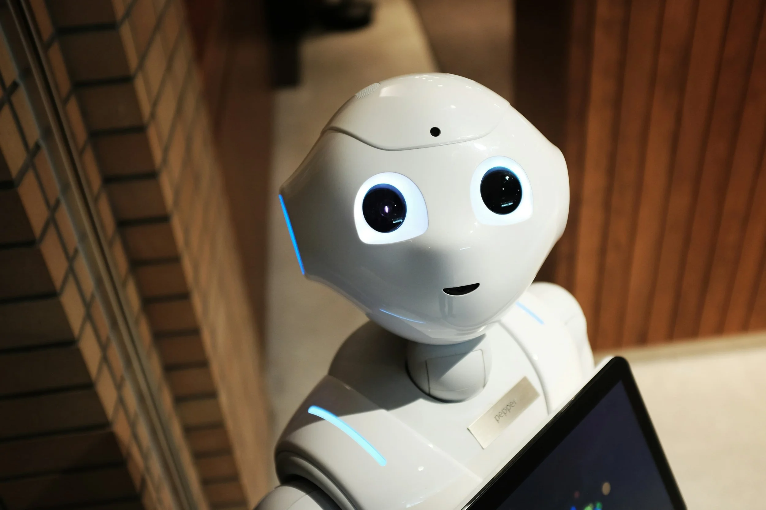 A friendly humanoid robot holding a tablet